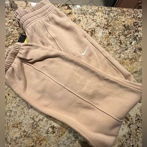 Beige, tan Nike sweatpants in size Small with white Nike logo on one side
